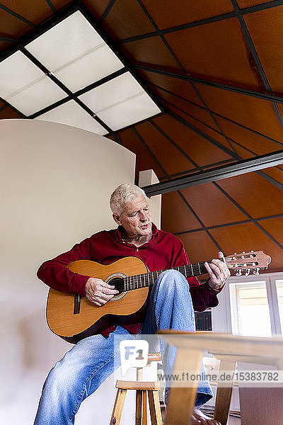 Älterer Mann spielt zu Hause Gitarre