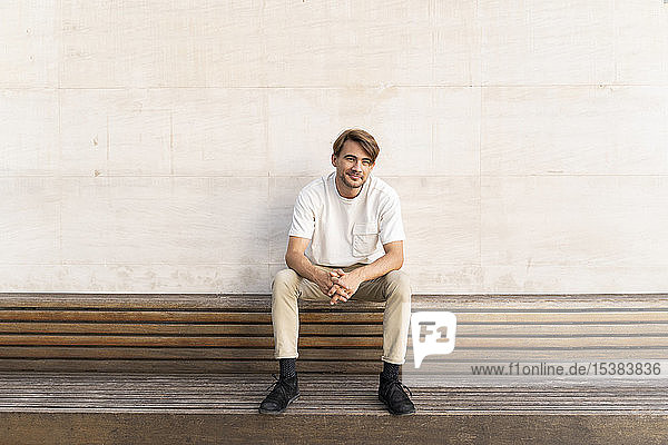 Portrait of smiling man sitting on wooden bench