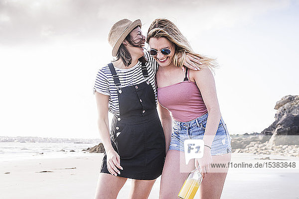 Zwei Freundinnen amüsieren sich  gehen am Strand spazieren