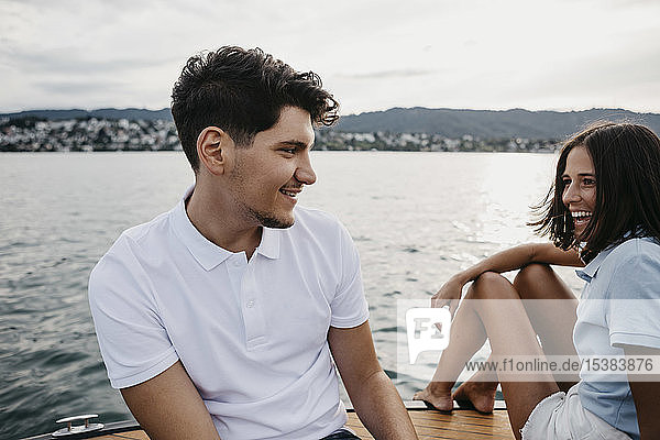 Glückliches junges Paar bei einer Bootsfahrt auf einem See