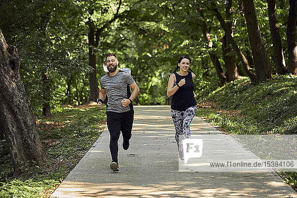 Sportliches Paar läuft auf Waldweg