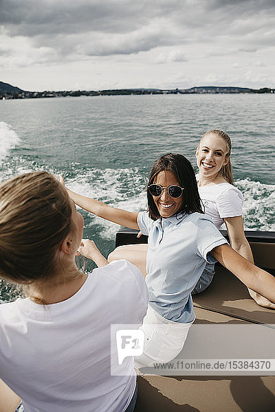 Happy female friends on a boat trip on a lake