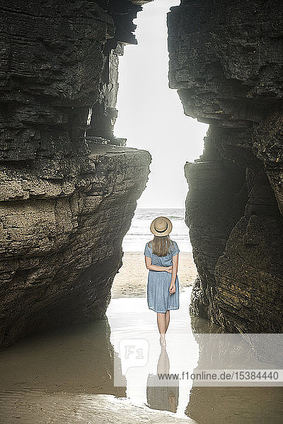 Am Strand der Kathedralen stehende Frau mit Felsen  Rückansicht  Galizien  Spanien