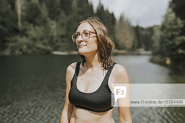 Lächelnde Frau steht an einem See