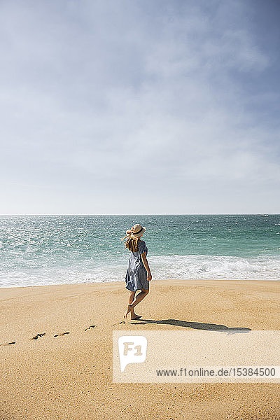 Rückansicht einer Frau  die am Strand spazieren geht  Nazare  Portugal