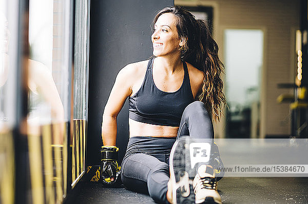 Smiling female boxer resting after boxing training