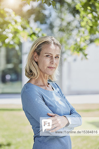 Porträt einer selbstbewussten blonden Frau in einem Park