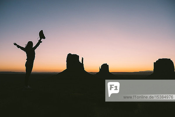 USA  Utah  Monument Valley  Silhouette einer Frau mit Cowboyhut  die den Sonnenaufgang genießt