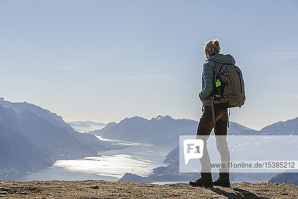 Italien  Como  Lecco  Frau auf einer Wanderung in den Bergen über dem Comer See  die die Aussicht genießt