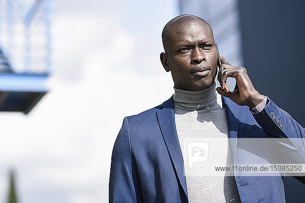 Porträt eines Geschäftsmannes am Telefon im blauen Anzug