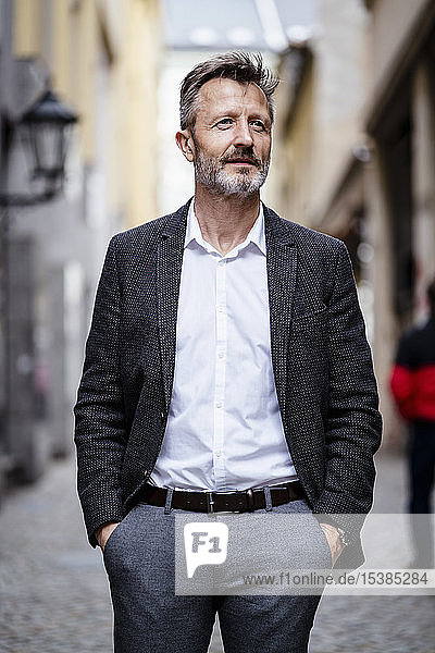Porträt eines reifen Geschäftsmannes mit grauem Bart in der Stadt