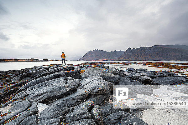 Norway  Lofoten Islands  Gimsoysand  man standing at rocky coast