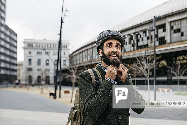 Porträt eines lächelnden Mannes mit Fahrradhelm in der Stadt