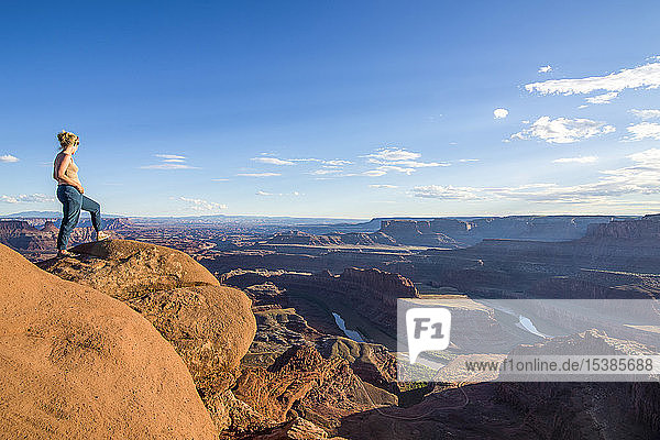 USA  Utah  Woman at a overlook over the canyonlands and the Colorado river from the Dead Horse State Park