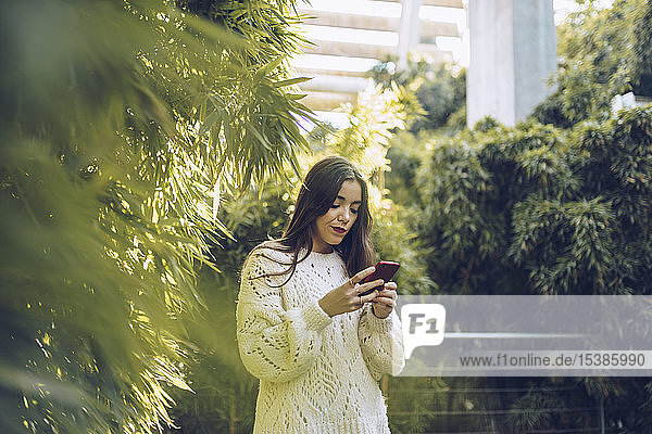 Young woman using cell phone in a park