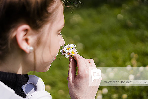 Junge Frau mit Gänseblümchen in einem Park
