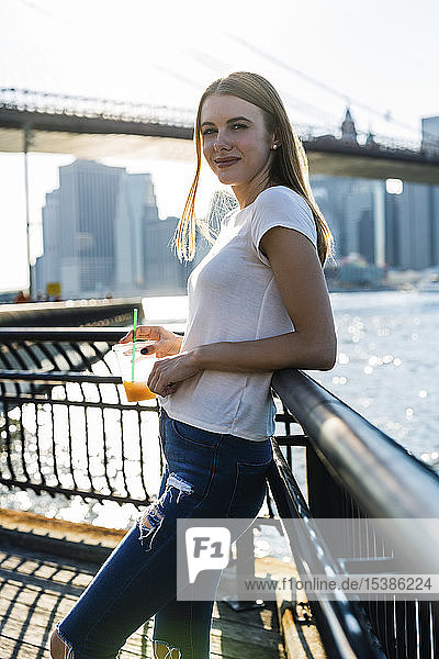 Junge Frau erkundet New York City mit Blick auf die Brooklyn Bridge