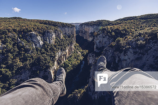 Spain  Navarra  Irati Forest  man's legs dangling above landscape with gorge