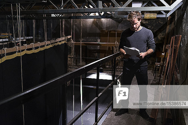 Actor at theatre studying script backstage