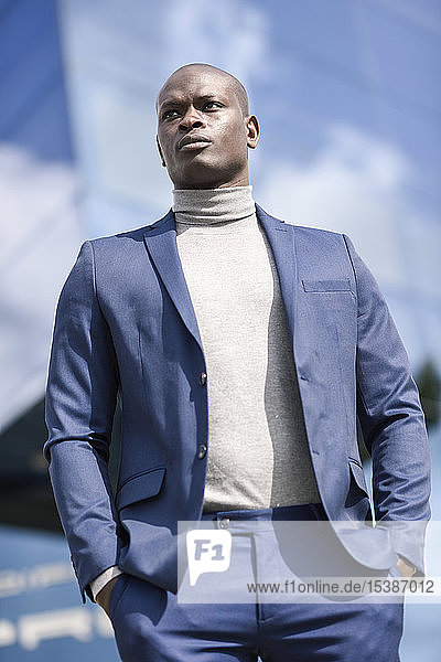 Porträt eines Geschäftsmannes in blauem Anzug und grauem Rollkragenpullover