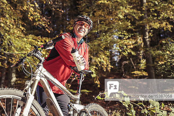 Man with mountainbike having a break in forest