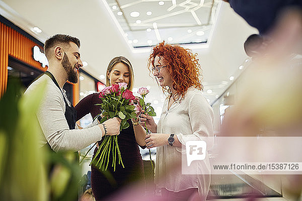 Florist berät Kunden im Blumengeschäft