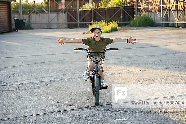 Portrait of smiling boy riding bmx bike freehanded