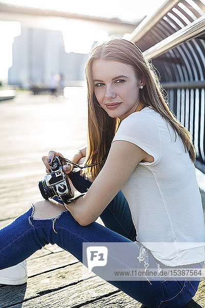 Junge Frau erkundet New York City und fotografiert an der Brooklyn Bridge