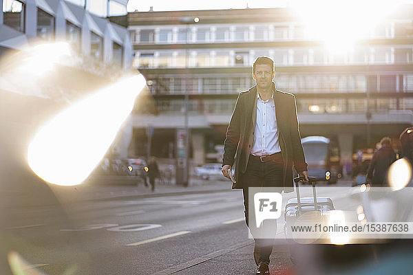Businessman with suitcase on the move in the city