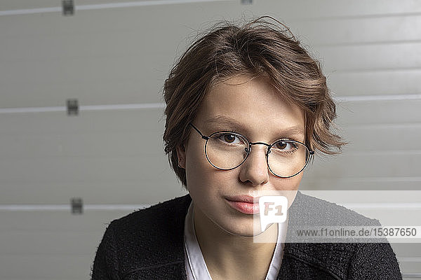 Porträt einer lächelnden jungen Frau mit Brille