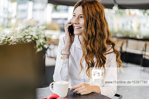 Young businesswoman sitting in cafe  talking on the phone