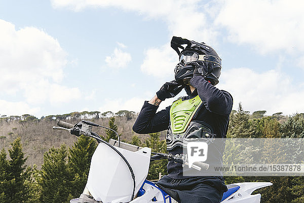 Motocross-Fahrer setzt Helm auf