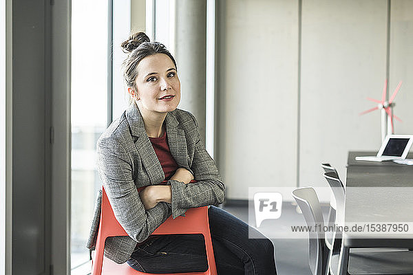 Portrait of smiling businesswoman sitting on chair in office
