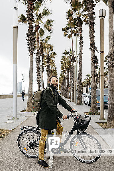 Porträt eines Mannes mit E-Bike auf einer Promenade