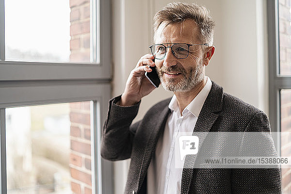 Businessman on cell phone at the window in office