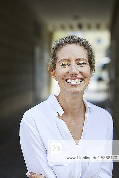 Porträt einer glücklichen Frau mit weißem Hemd in der Stadt