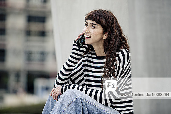 young woman wearing striped shirt  using smartphone