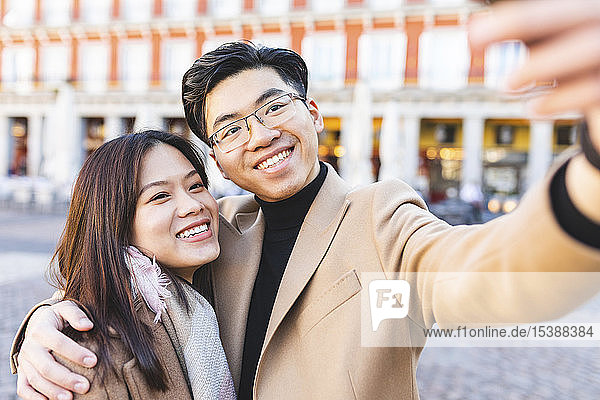 Spain  Madrid  happy young couple taking a selfie in the city