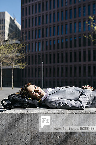 Young businesswoman with red shoes relaxing on a bench in the city