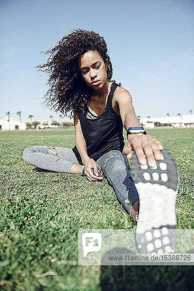 Sporty young woman stretching outdoors