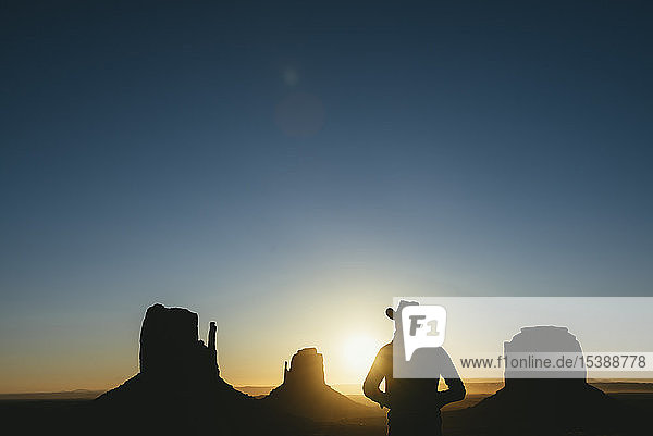 USA  Utah  Monument Valley  silhouette of man with cowboy hat watching sunrise