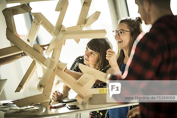 Group of creative professionals building wood object for a project