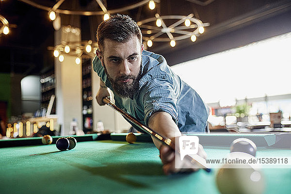 Porträt eines konzentrierten Mannes beim Billardspielen