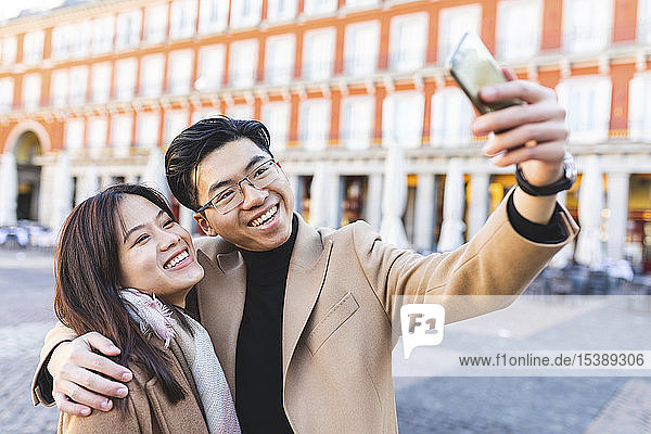 Spanien  Madrid  glückliches junges Paar  das sich in der Stadt ein Selfie gönnt