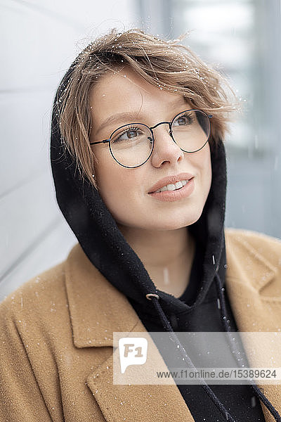 Portrait of young woman at snowfall