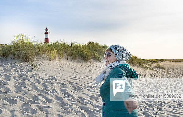 Germany  Sylt  North Sea  woman strolling on sandy beach