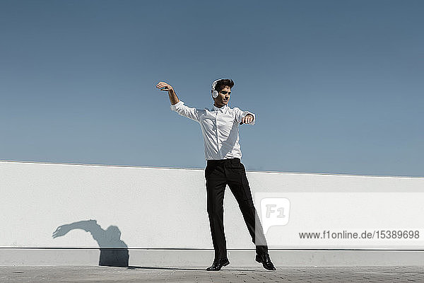 Ballet dancer with headphones practising on roof terrace