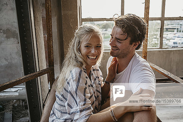 Glückliches junges Paar kuschelt in einem alten Gebäude