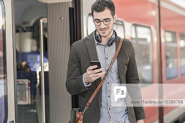 Young man using cell phone at commuter train