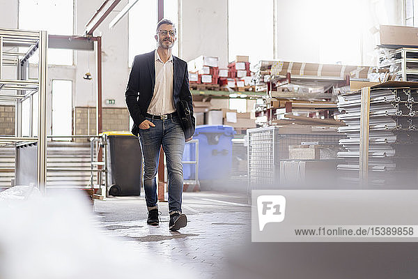Businessman walking in factory warehouse